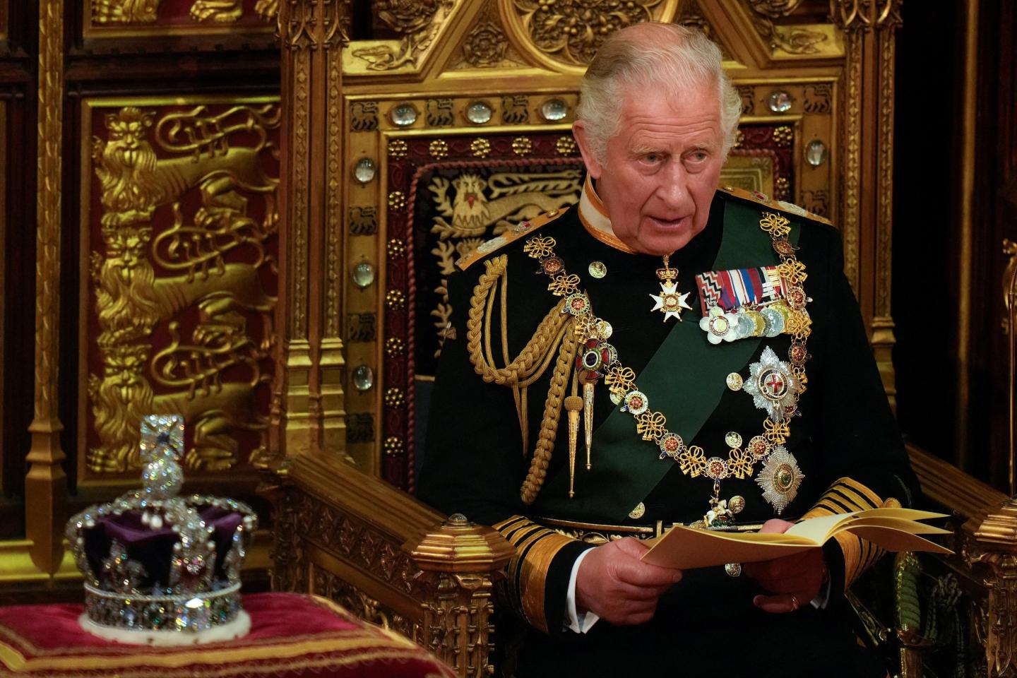 King Charles sits in the House of Lords beside the crown.