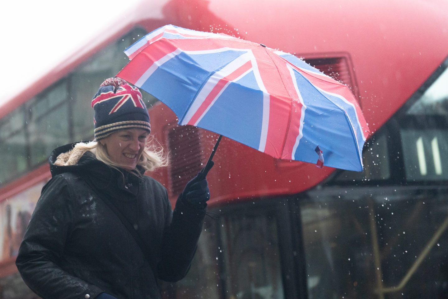 A woman with a Union Jack umbrella braves the British weather.