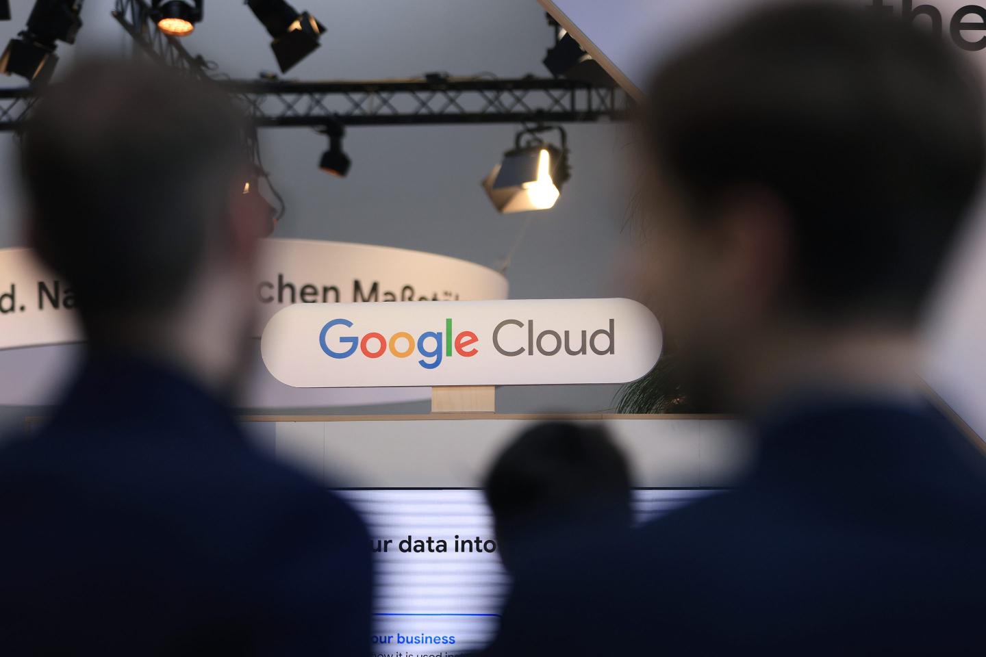 Blurred backs of heads in front of a Google Cloud sign.