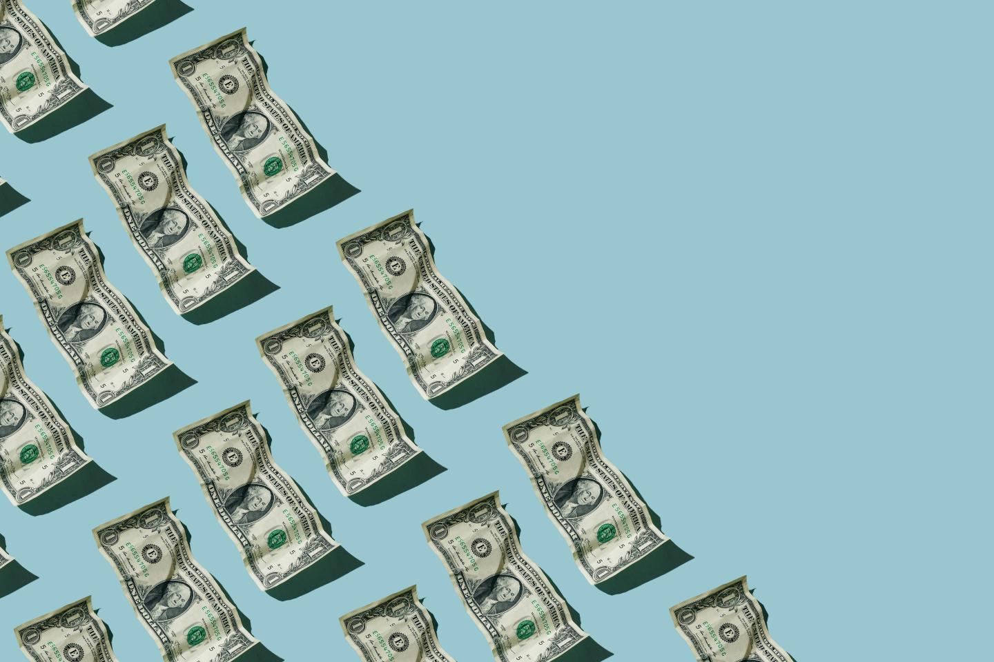 Crumpled one dollar bills on blue background
