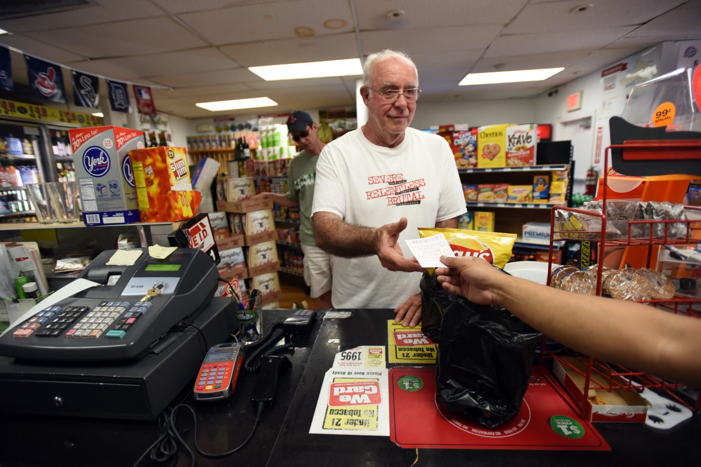 A man pays for potato chips at a convenience store.