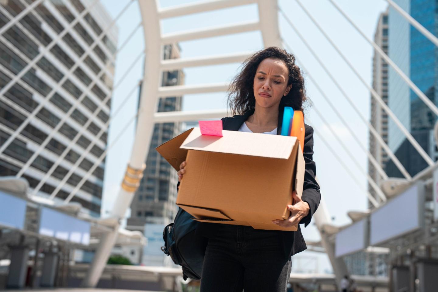 worker carrying box of belongings after being sacked