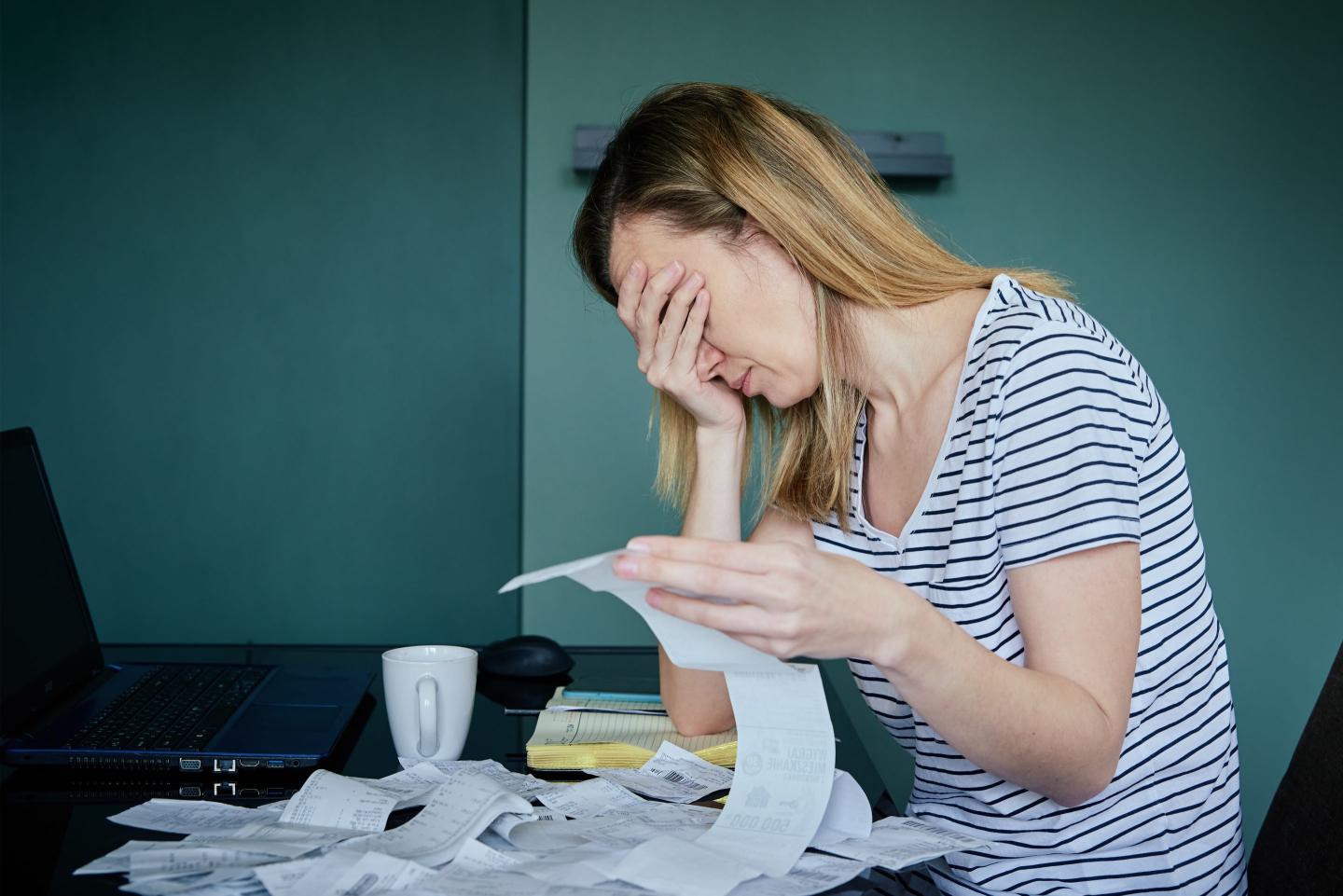 Woman Calculating Payment Bill In Kitchen.