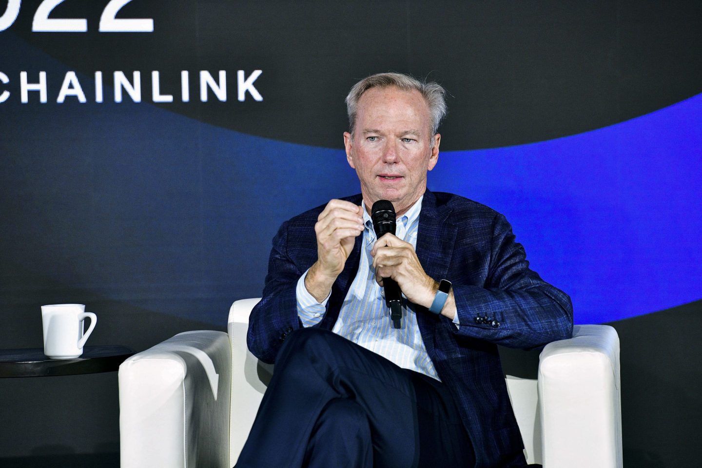 A photo of Eric Schmidt holding a microphone