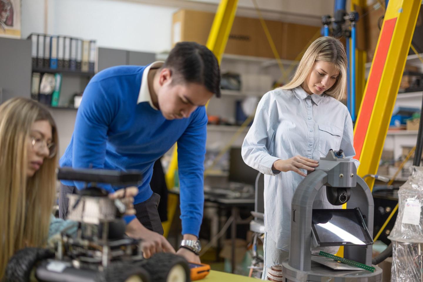 man and women at work in machine shop