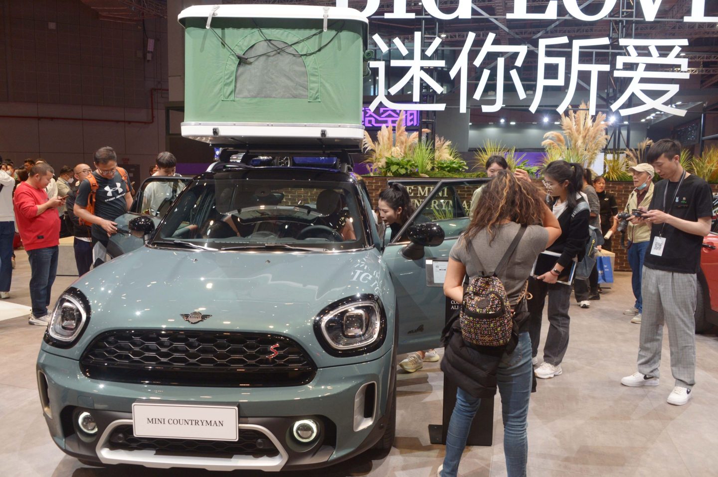 Attendees at the Shanghai Auto Show look at a car from BMW Mini.
