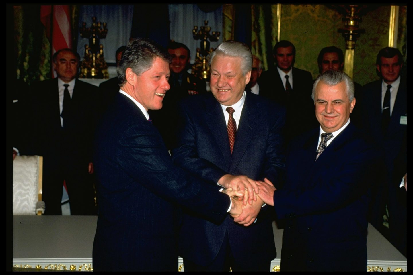 U.S. President Bill Clinton, Russia President Boris Yeltsin, and Ukraine President Leonid Kravchuck shaking hands after signing a nuclear disarmament agreement in 1994.
