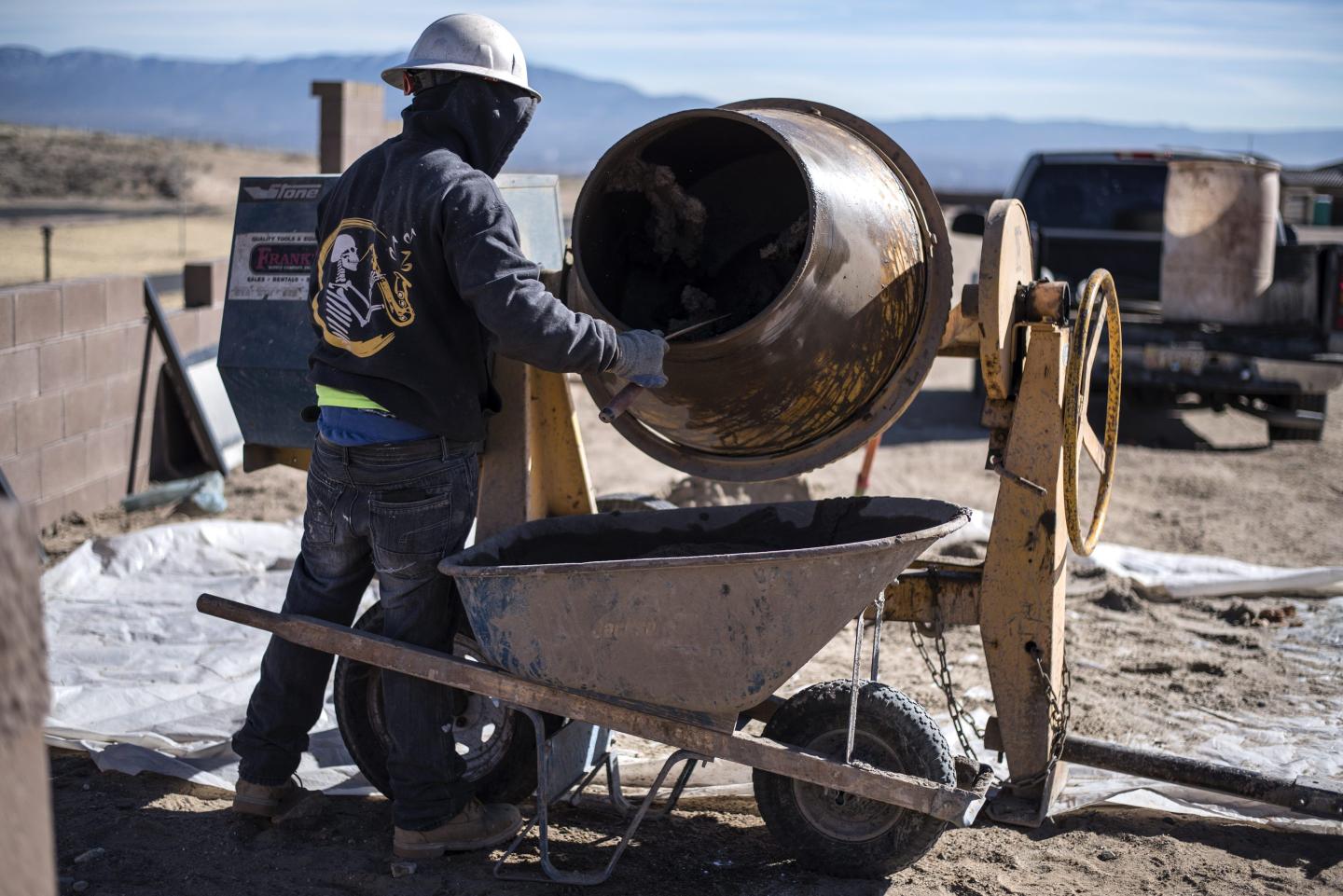 A contractor mixes cement for a home under construction in Albuquerque