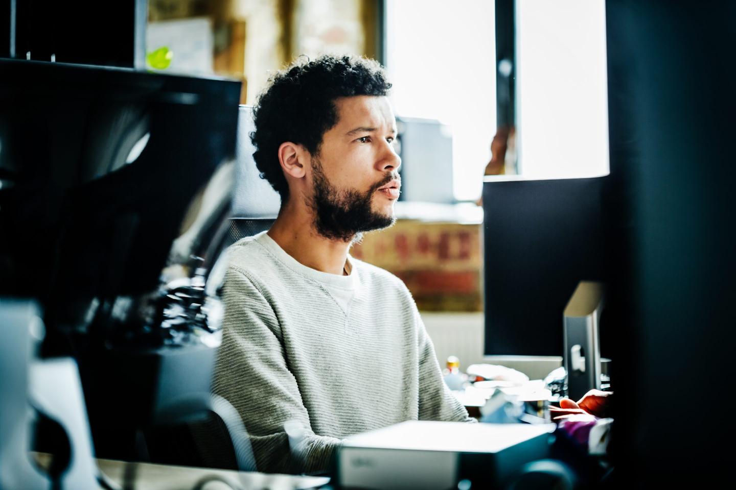 Young casual businessman portrait working on a computer.