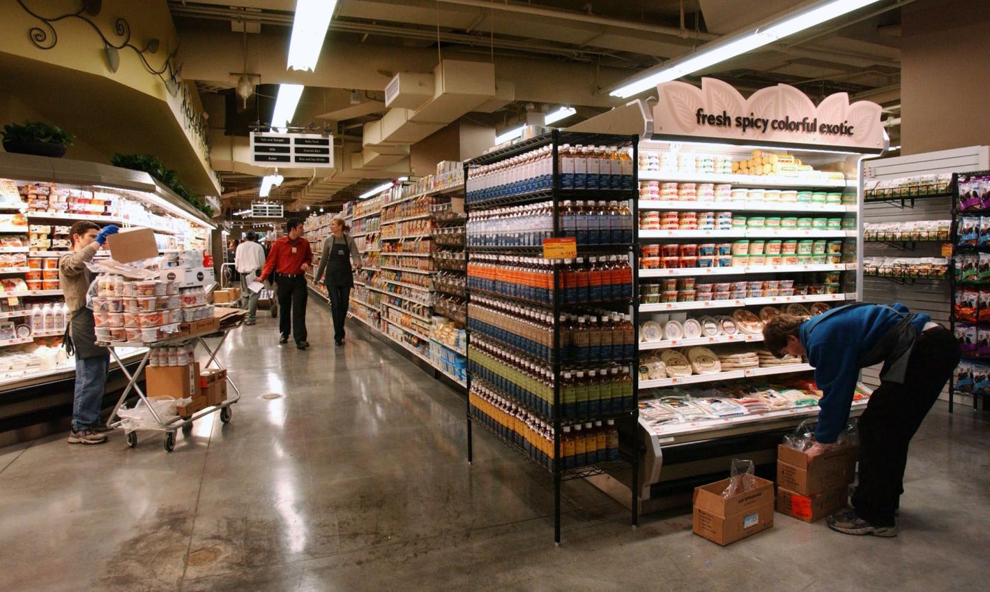Workers finish stocking shelves for the opening of a Whole Foods supermarket