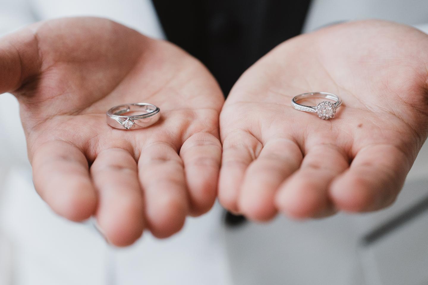 Midsection Of Man Holding Wedding Rings.