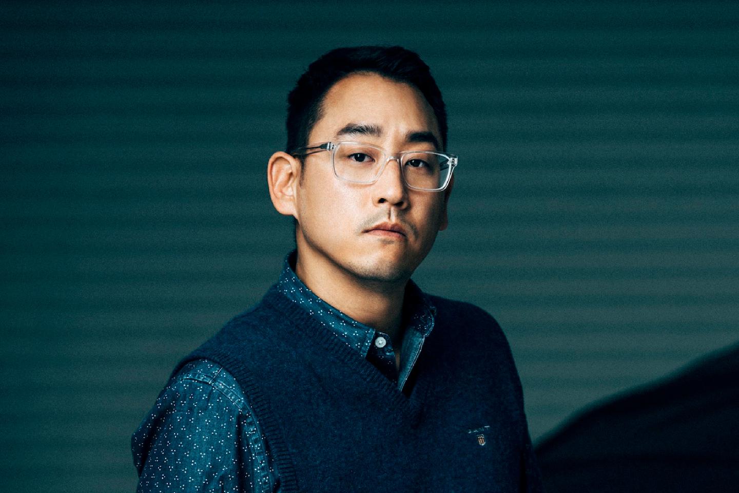 Portrait of Richard Kim on blue striped background.