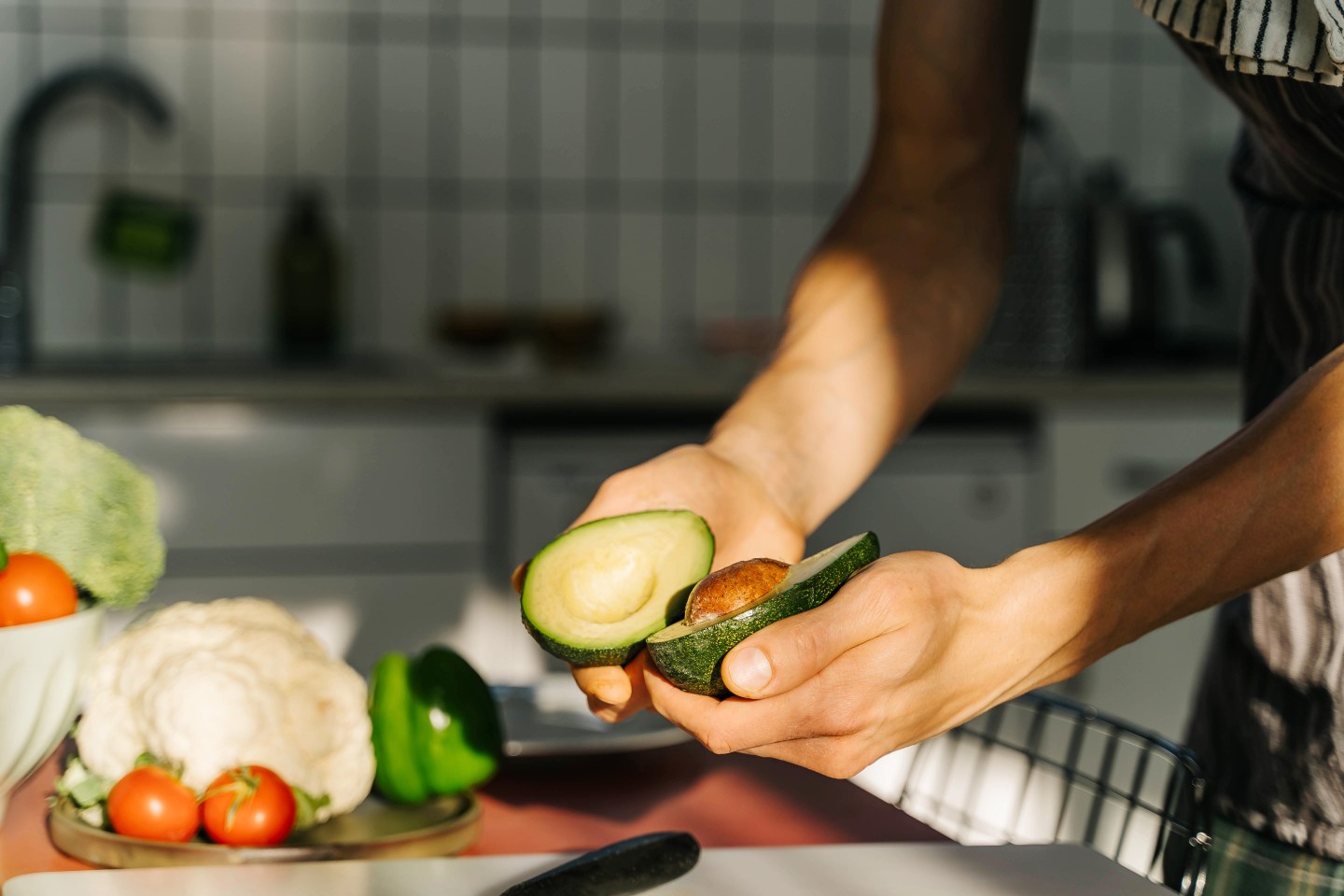 Young man cooking guacamole in light kitchen at home.