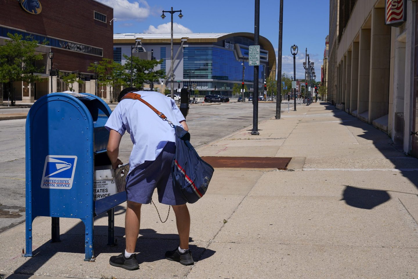 A postal worker empties a box near the Fiserv Forum on Aug. 18, 2020, in Milwaukee.