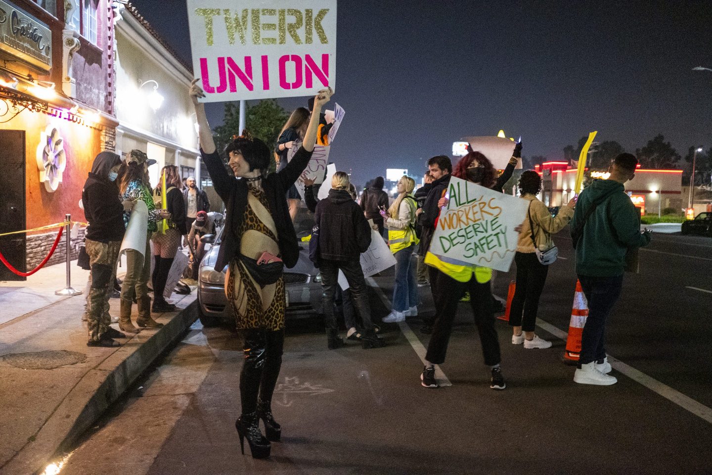 A protester identified as "Reagan" holds a sign outside the Star Garden Topless Dive Bar on Saturday, March 26, 2022 in the North Hollywood area of Los Angeles.