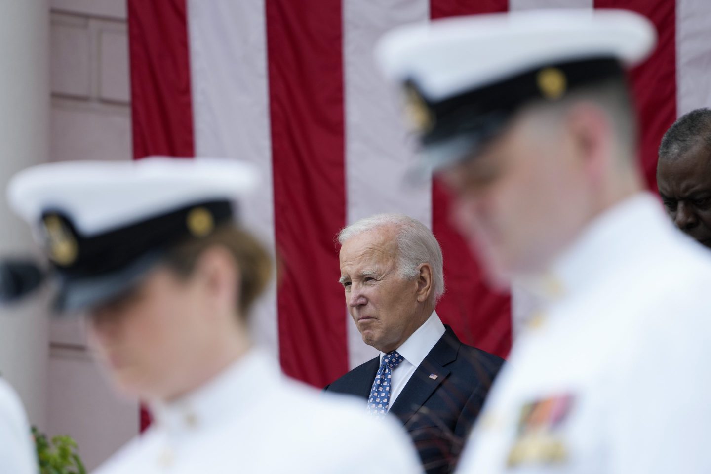 President Joe Biden stands with Defense Secretary Lloyd Austin as the national anthem is played at the Memorial Amphitheater of Arlington National Cemetery in Arlington, Va., on Memorial Day, on May 29, 2023.