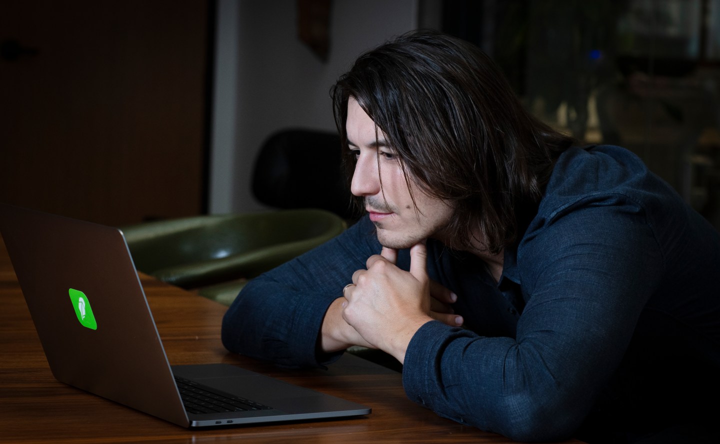 Vlad Tenev, CEO and cofounder of Robinhood, looks at a Robinhood-branded laptop.