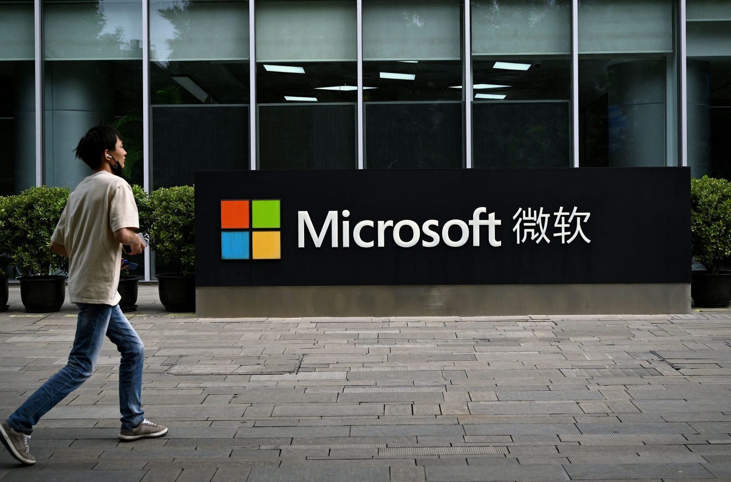 A man walks past a sign for Microsoft's Beijing office in 2021.