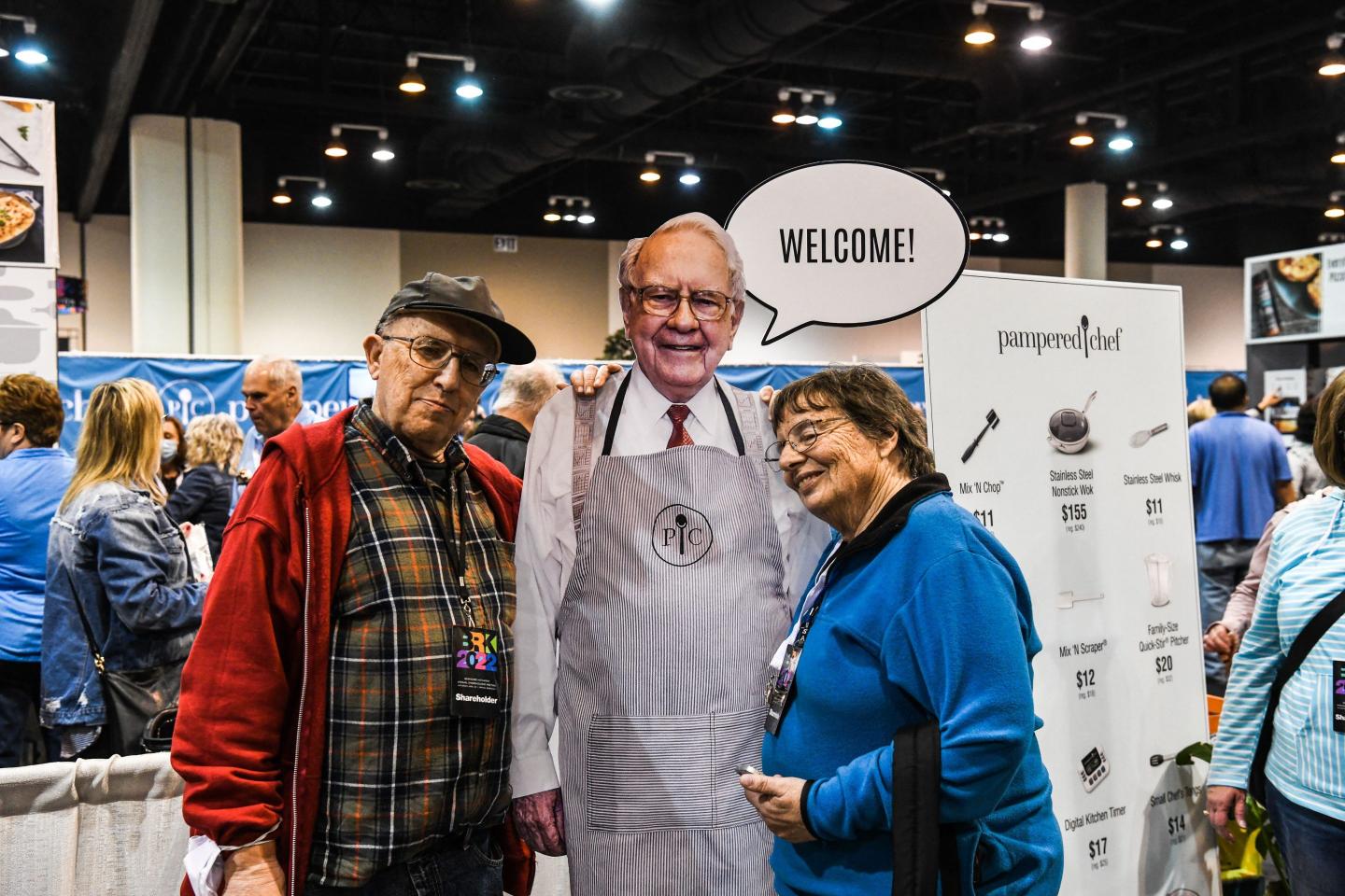 Investors pose next to a likeness of Berkshire Hathaway CEO Warren Buffett.
