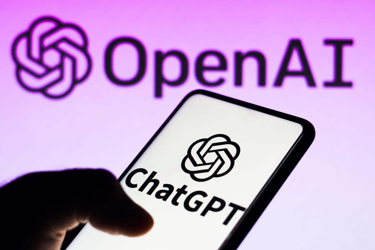 In this photo illustration, the ChatGPT logo is seen displayed on a smartphone and the OpenAI company logo on background.
