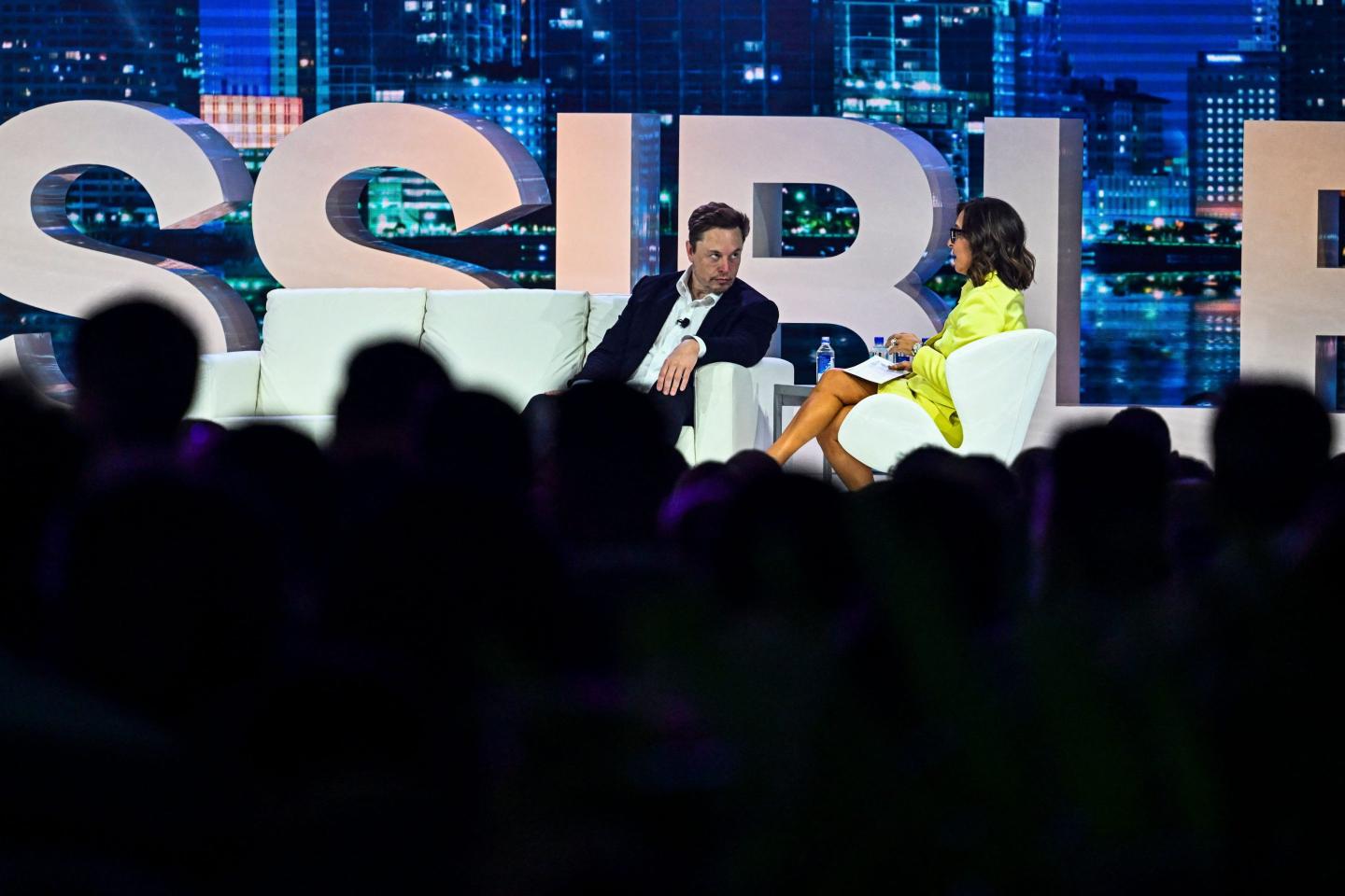 Twitter CEO Elon Musk speaks to NBCUniversal ad executive Linda Yaccarino at the "Twitter 2.0: From Conversations to Partnerships" marketing conference in Miami Beach, on April 18, 2023. 
