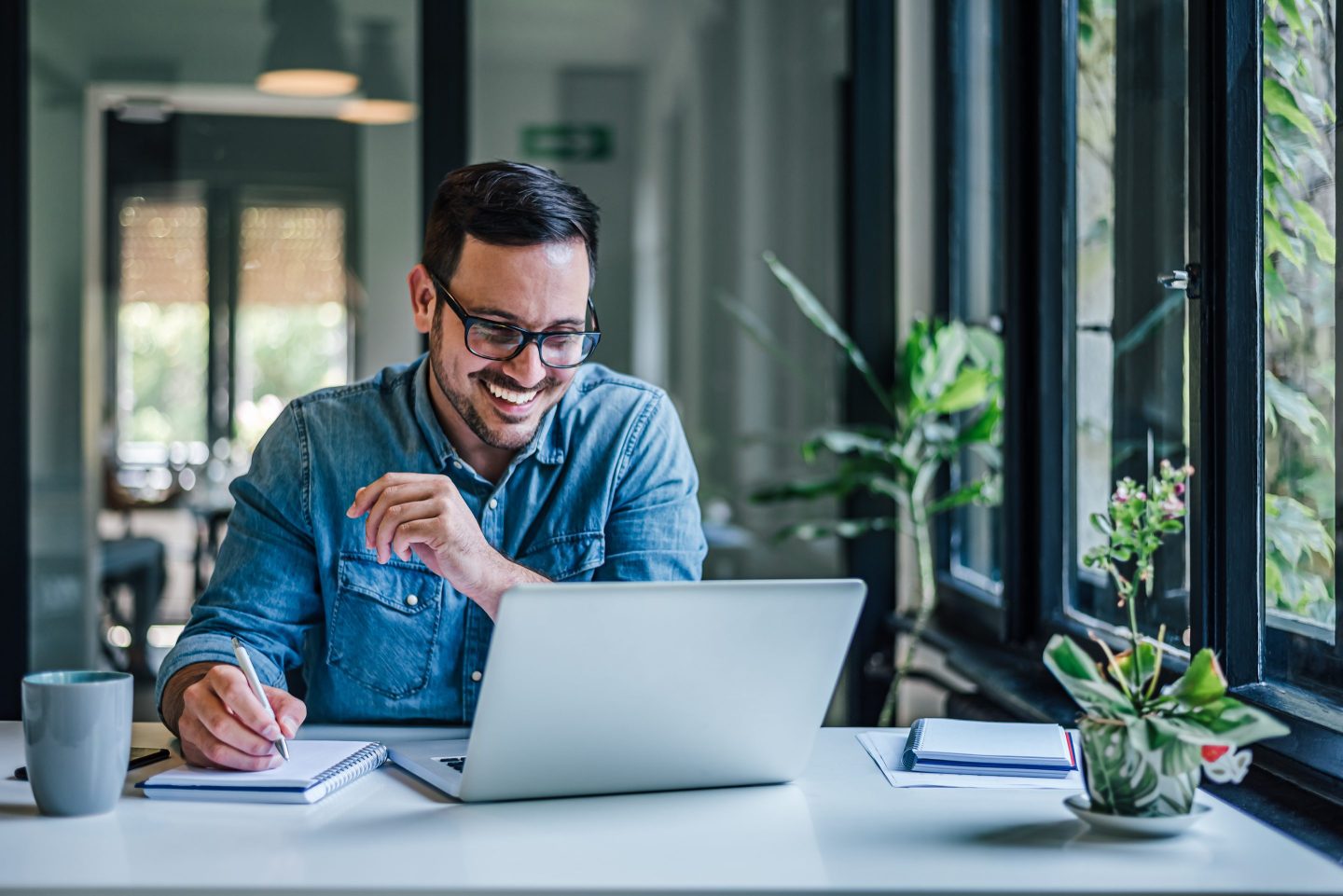 business man taking notes with laptop