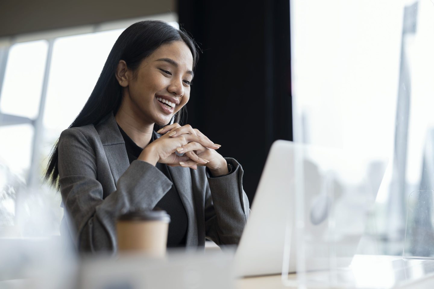 Young woman having a video call on her laptop with clients