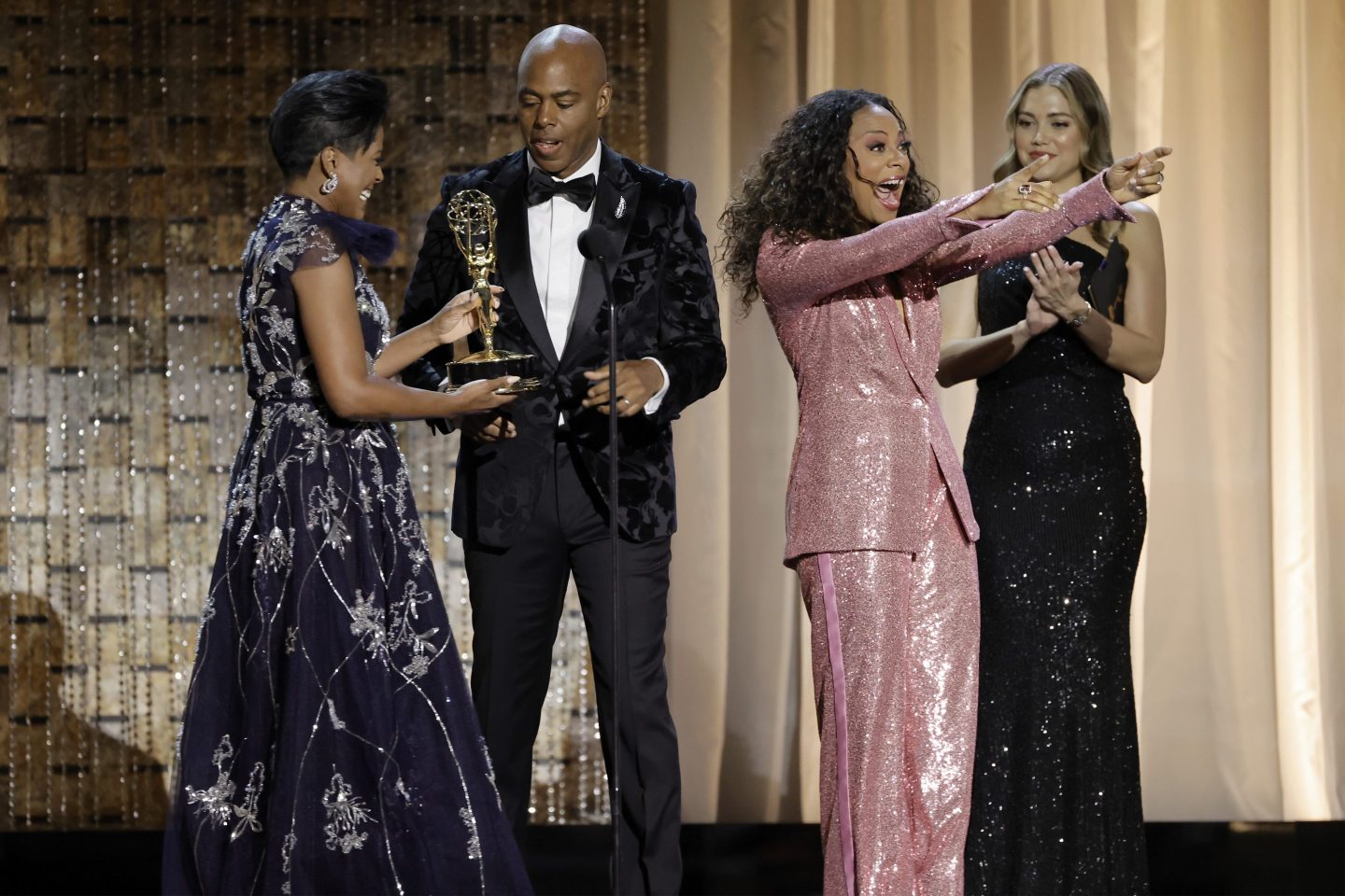Kevin Frazier and Nischelle Turner (C) accept the Outstanding Entertainment News Series award from Tamron Hall, (L) onstage during the 49th Daytime Emmy Awards.