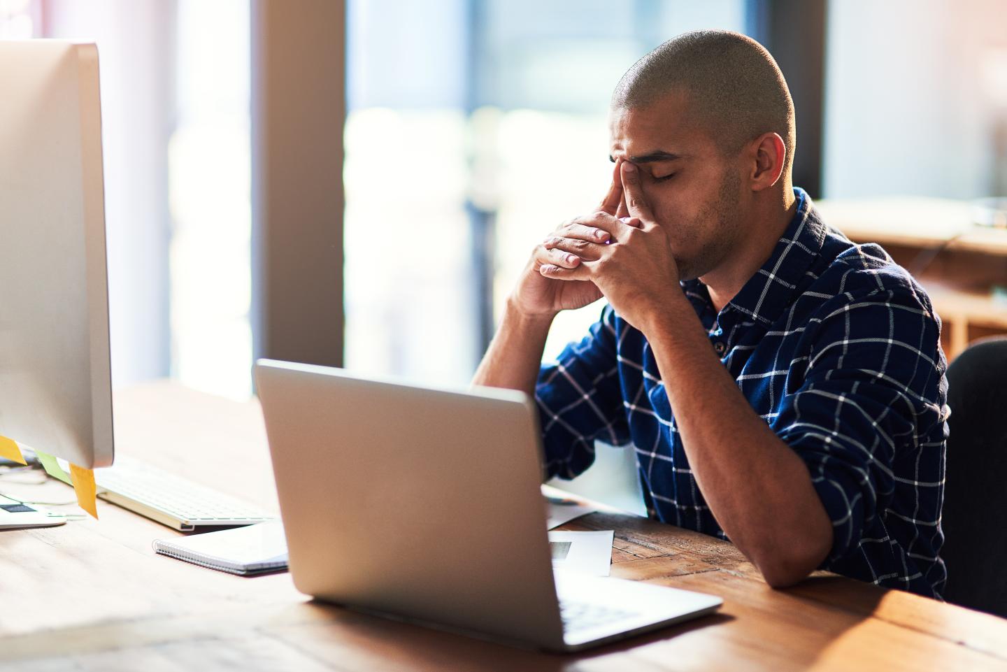 Cropped shot of a young designer looking stressed out while working at his office desk