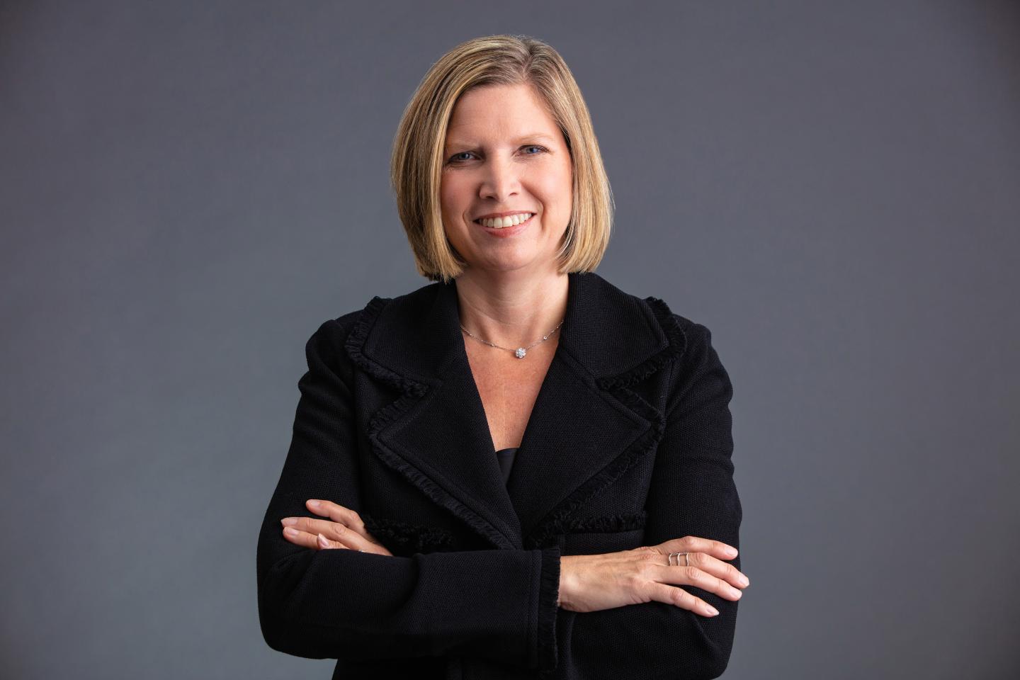 woman wearing a suit jacket and smiling