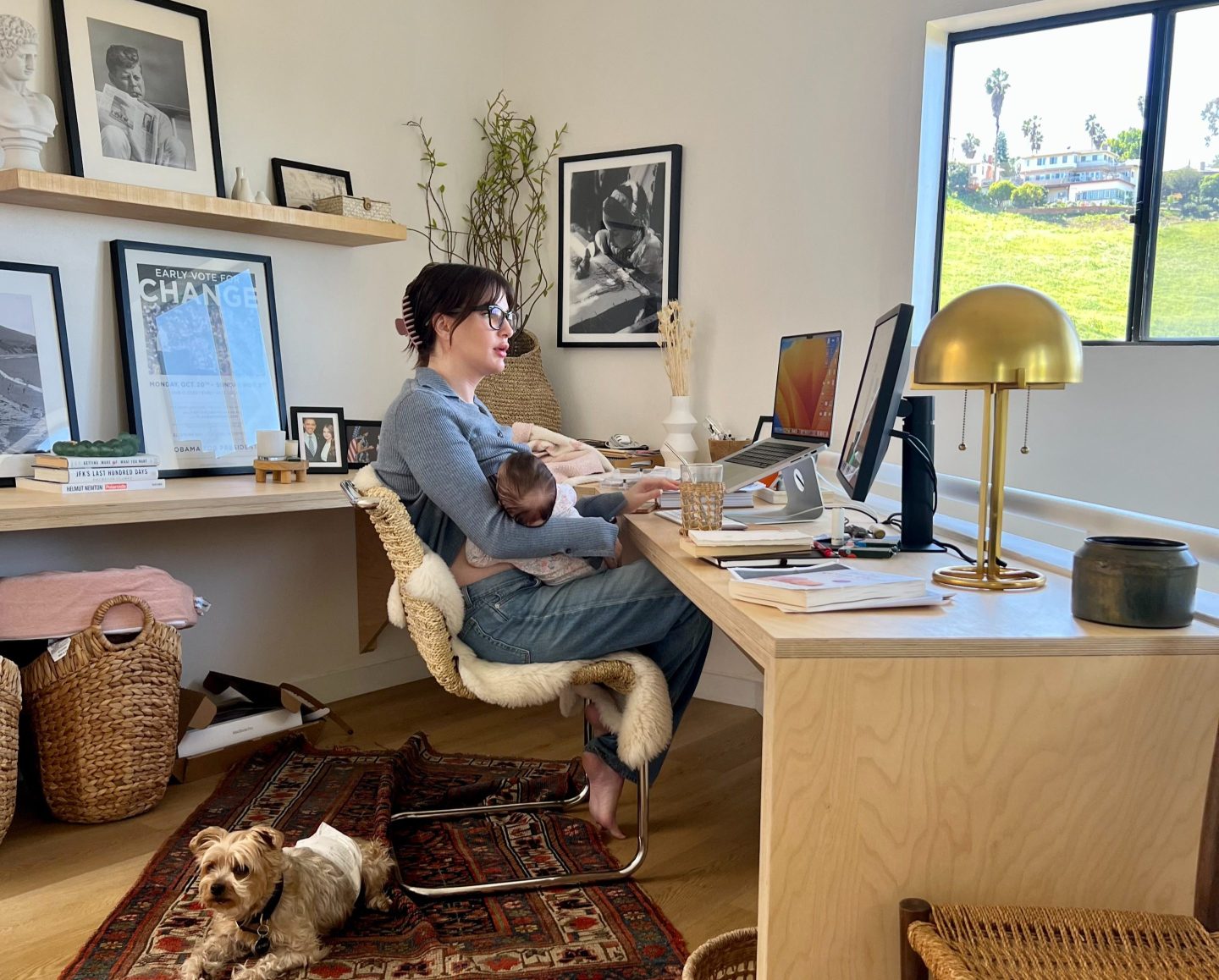 Lisa Conn, CEO of Gatheround, nurses her newborn while leading a team meeting on Gatheround's video meetings platform from Los Angeles, California in March 2023.