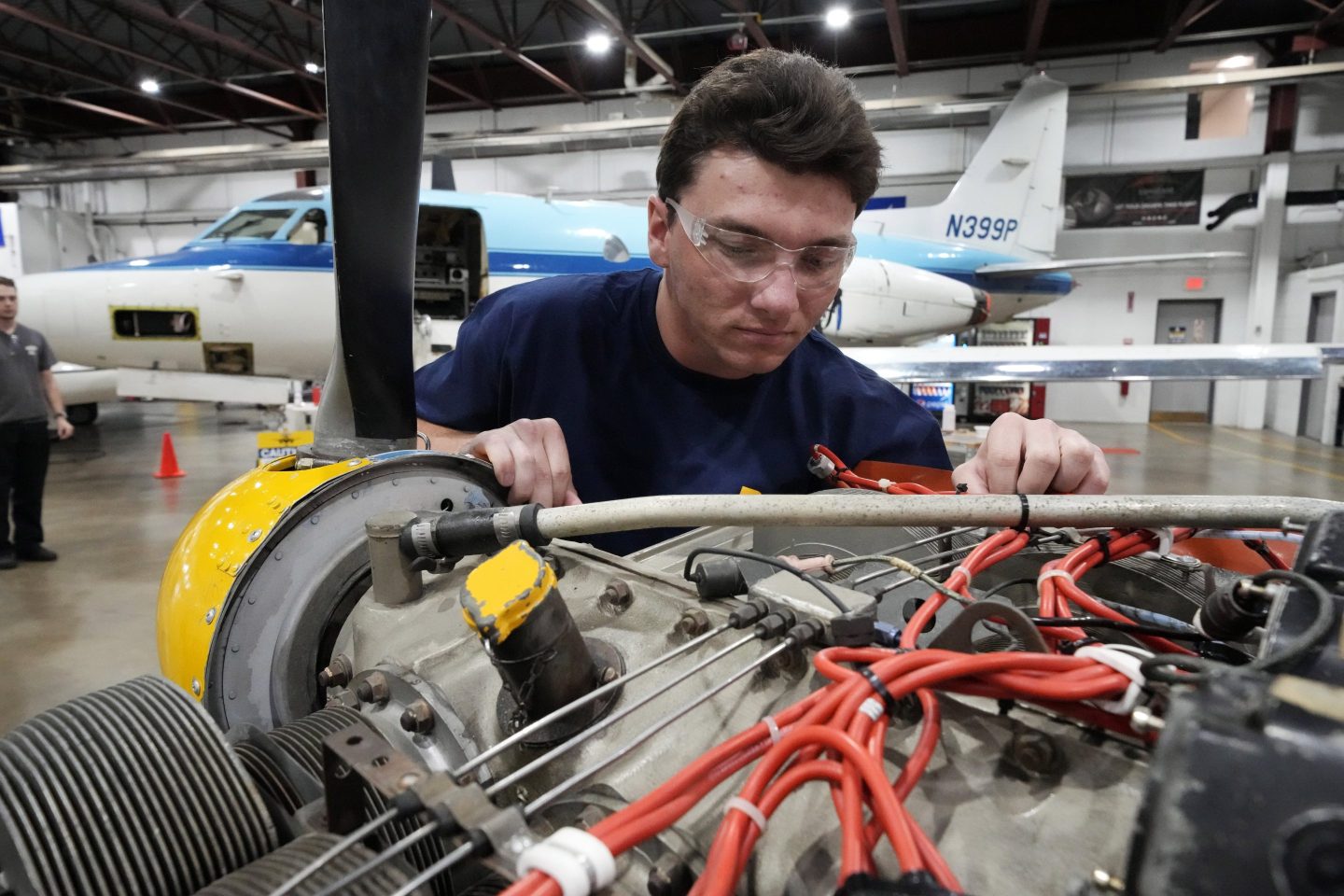 Students at the Pittsburgh Institute of Aeronautics from left: Nikki Reed, William Onderdonk, Jeffrey Natter and Joshua Lindberg study an engine on a Cessna 310 aircraft in West Mifflin, Pa., Tuesday, May 2, 2023.