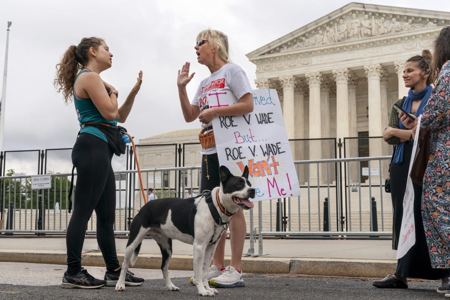 Lilo Blank of Philadelphia, left, who supports abortion rights, and Lisa Verdonik, of Arlington, Va., who is anti-abortion, talk about their opposing views on May 13, 2022, outside the Supreme Court in Washington.