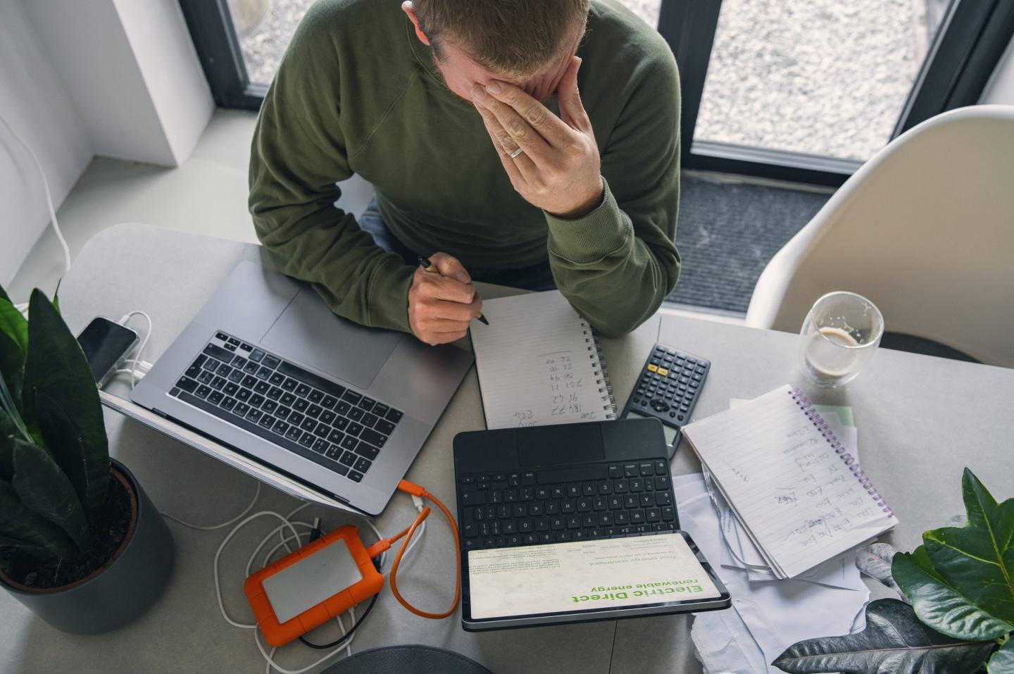 A man goes through his home finances at the dining table.