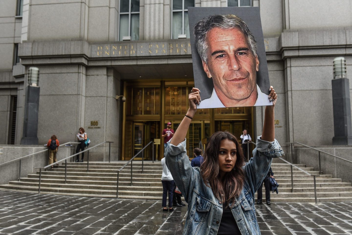 A protest group called "Hot Mess" hold up signs of Jeffrey Epstein in front of the federal courthouse on July 8, 2019 in New York City.