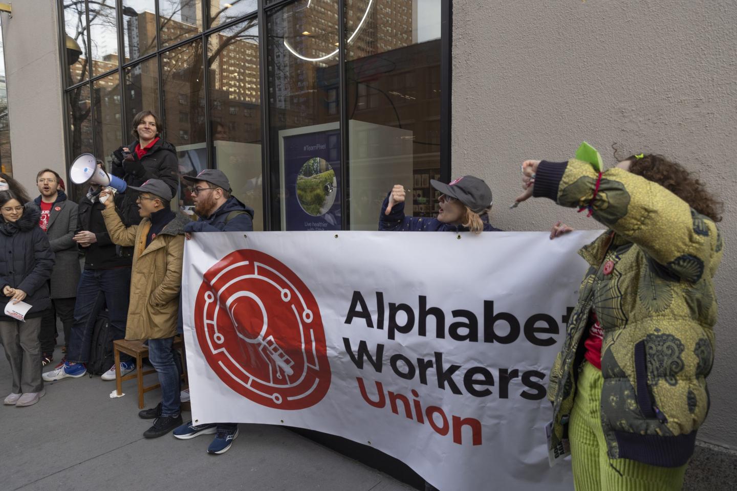 People holding up a sign that says "Alphabet workers union"
