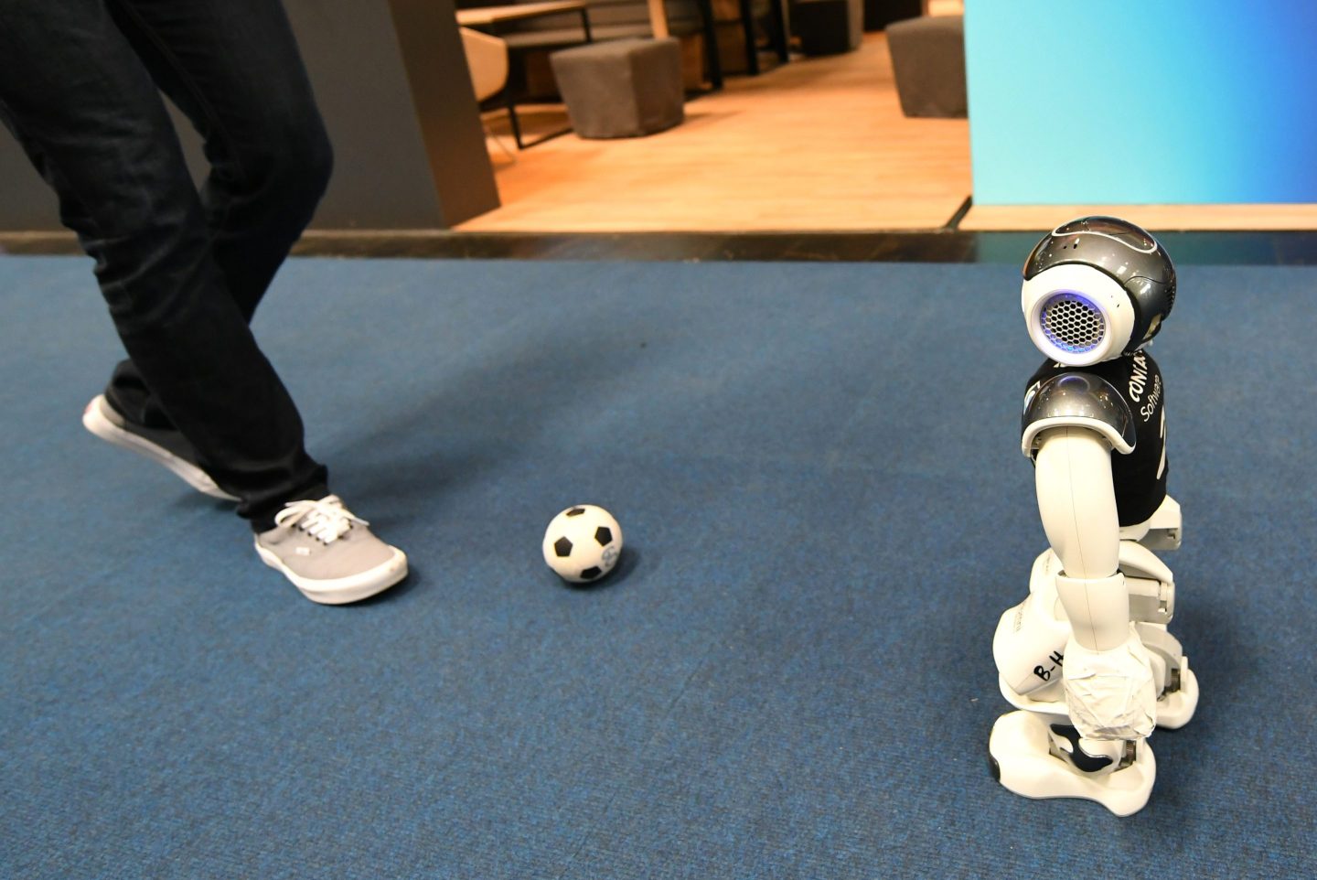 A visitor plays football with an intelligent robot at a trade fair in Hannover, Germany in April 2023.