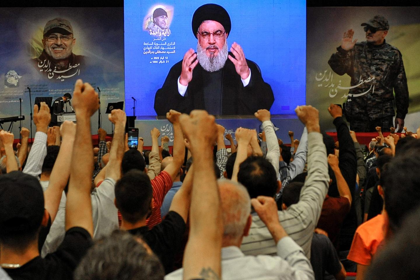 Pro-Iranian Hezbollah supporters raise their fists to salute party leader Hassan Nasrallah. 