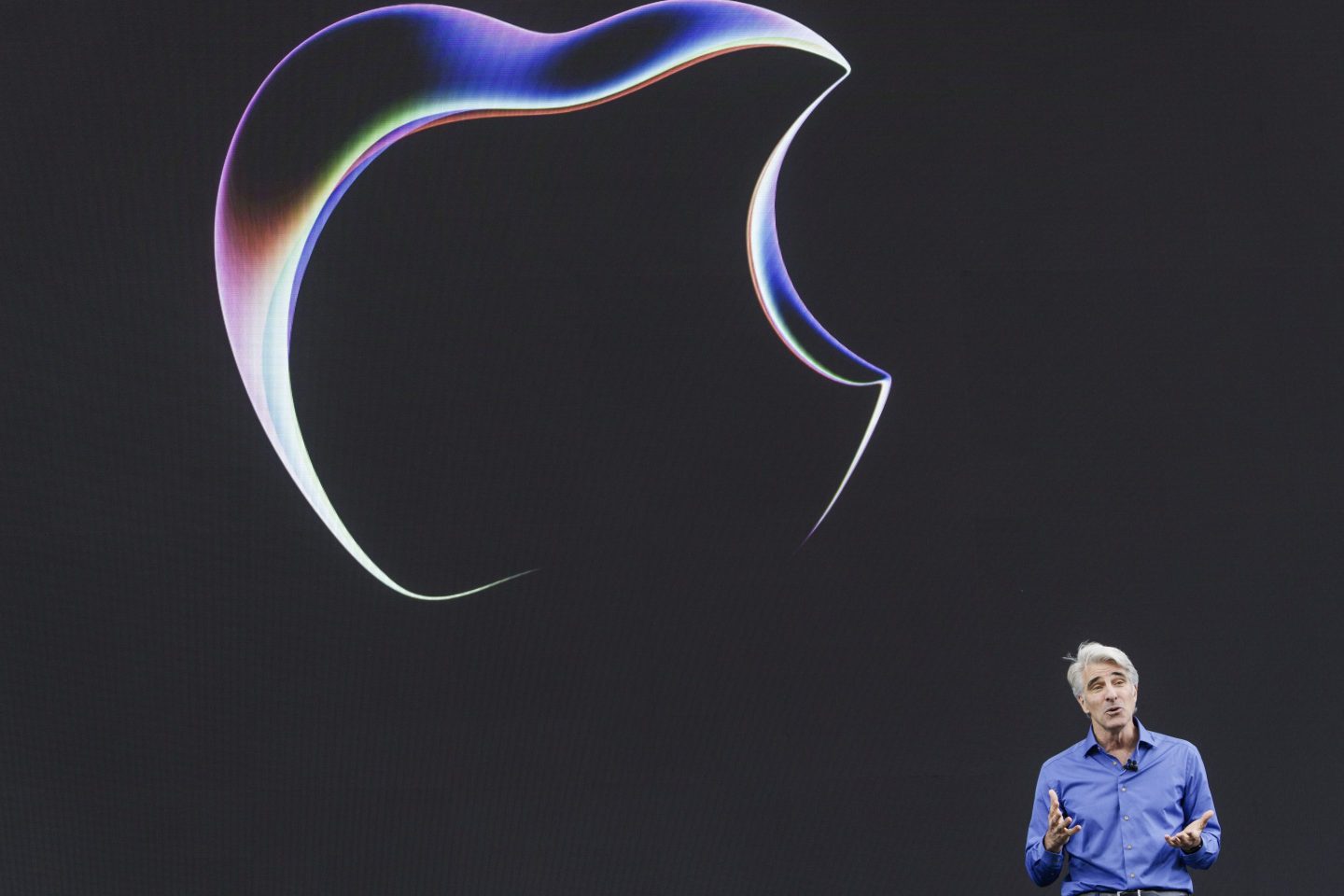 A picture of Craig Federighi against a big logo of Apple