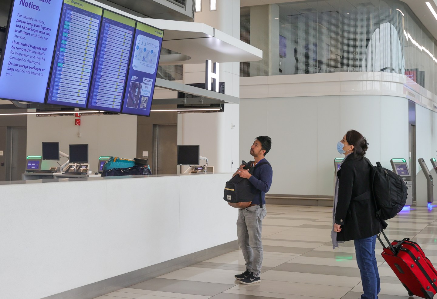 Passengers check an information board after the US Federal Aviation Administration (FAA) warned travelers to expect flights to be delayed at LaGuardia airport in New York City as smoke from a series of wildfires in Canada limited visibility on Wednesday, June 7, 2023.