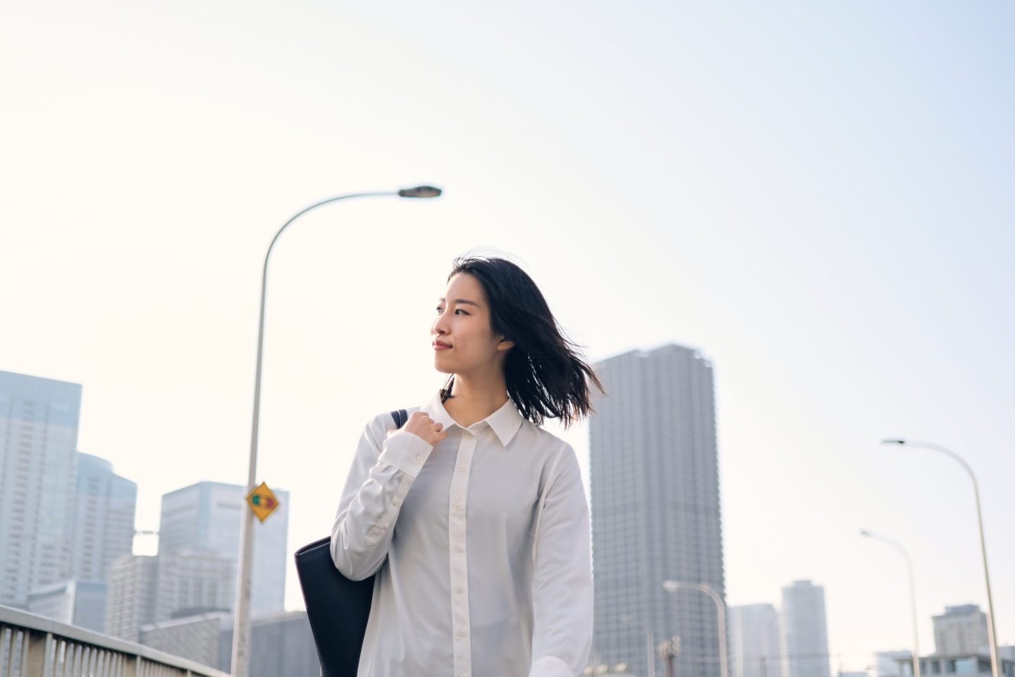 A Japanese businesswoman walking in an unidentified city.