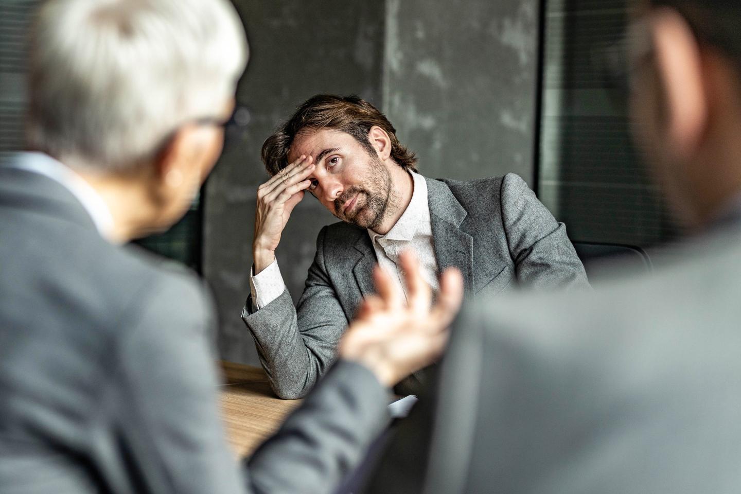 A man looks confused while staring at a coworker.