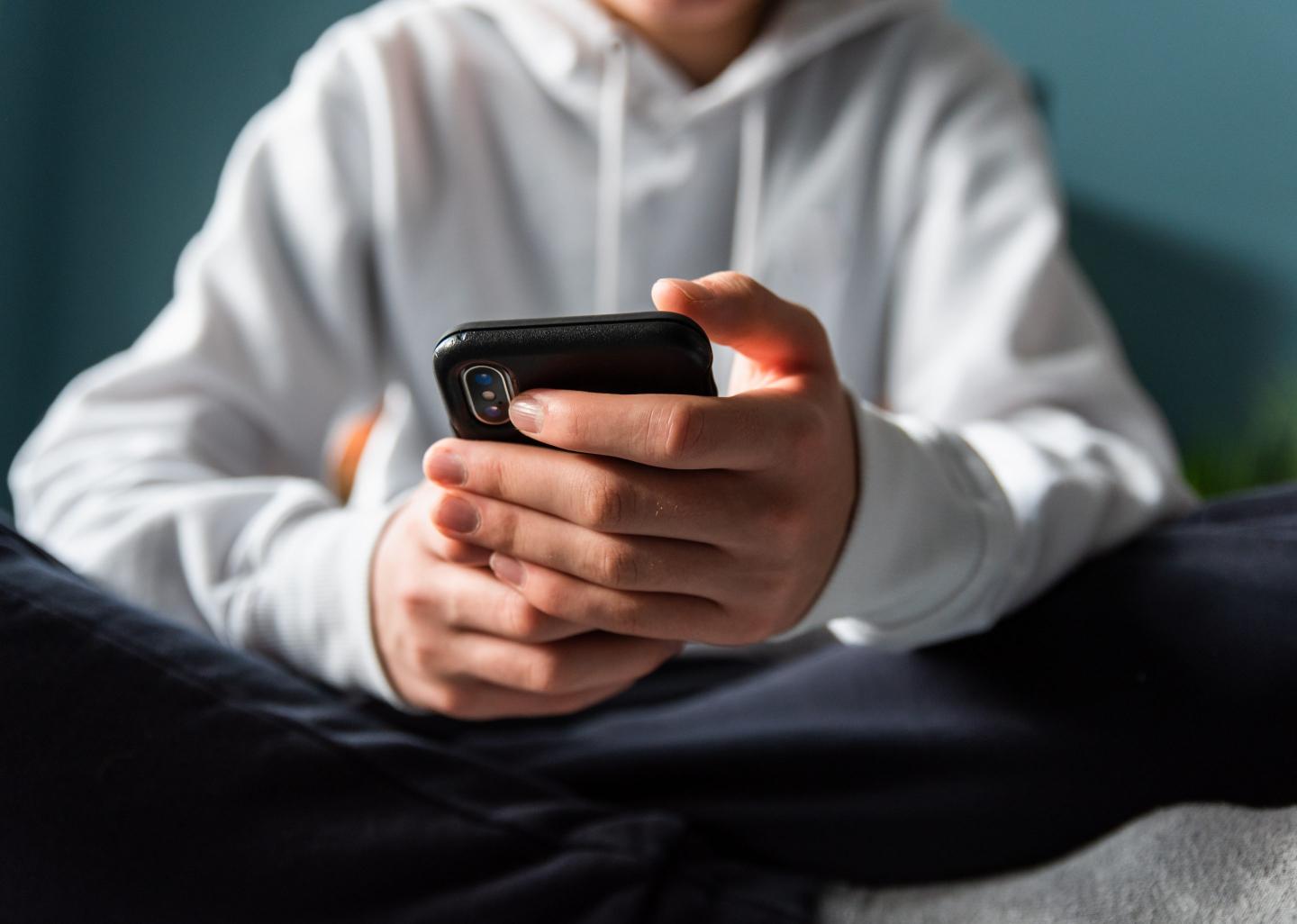 Close-up of a teen’s hands holding a smartphone
