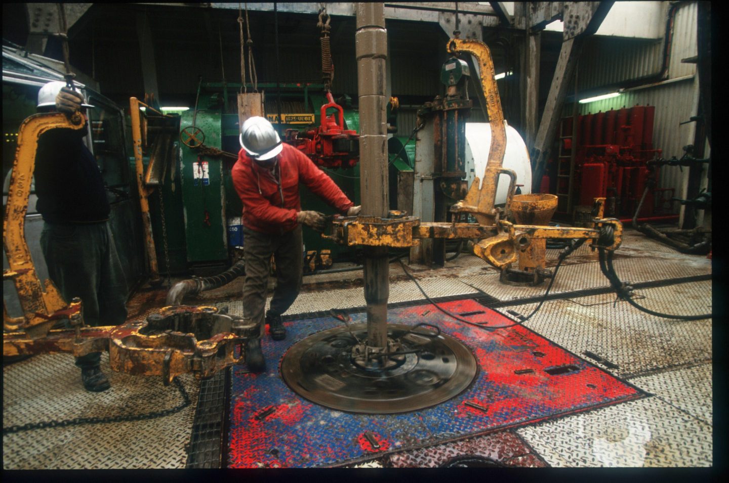 A worker operates a drill on an offshore oil rig in the Caspian Sea about 30 miles from Meghdad March 1997 in Iran.