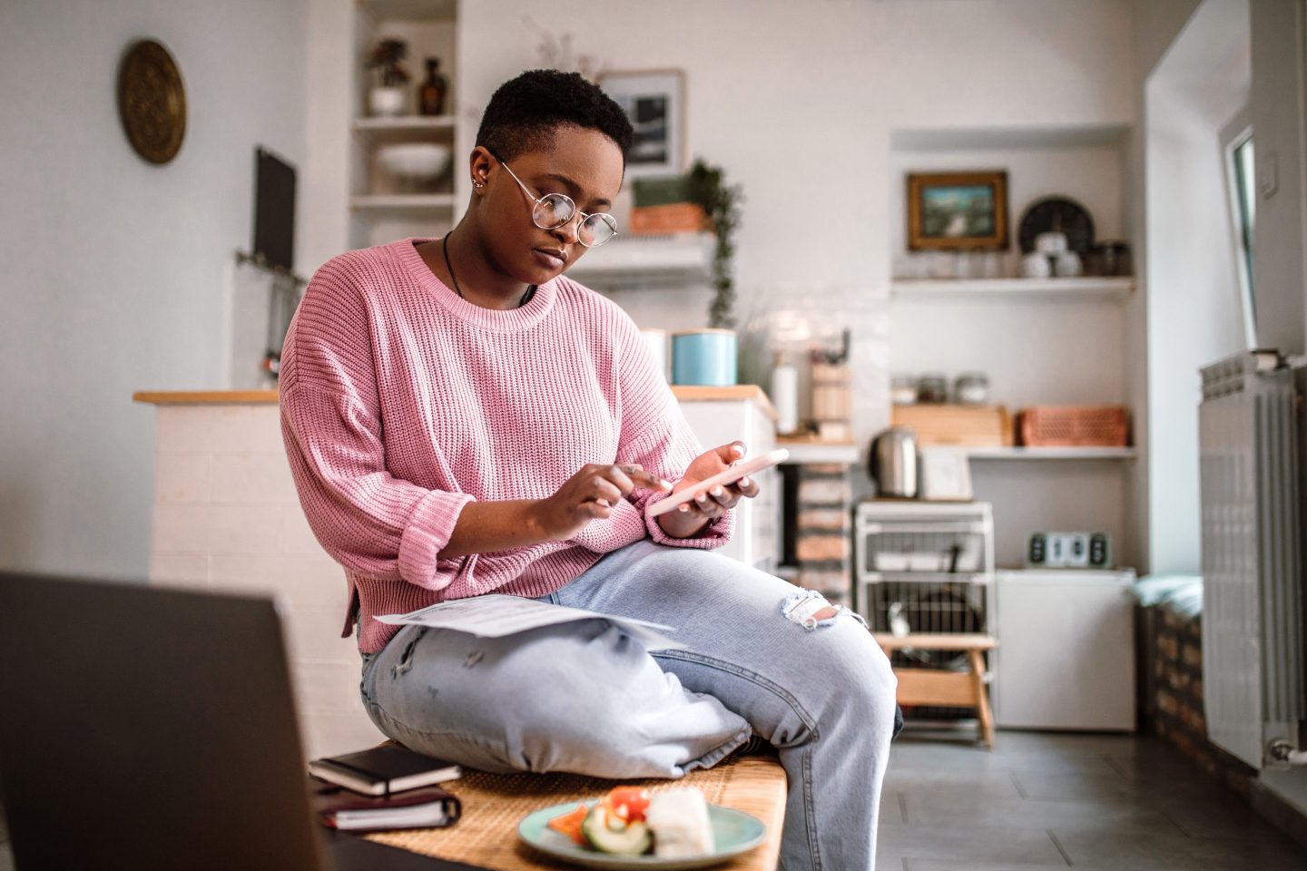 Young woman doing home finances on her phone