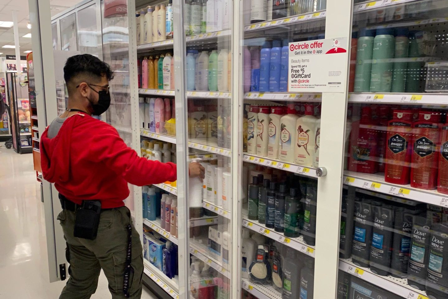 A Target employee stocks personal hygiene items in new locked security shelving.