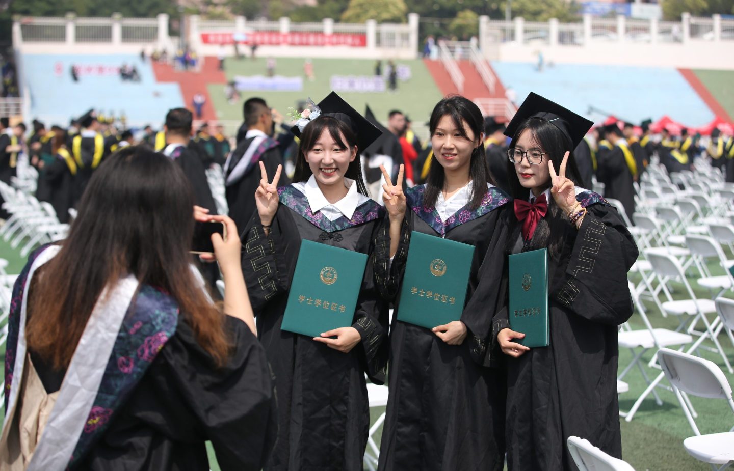 A group of three graduate women posing for a photo