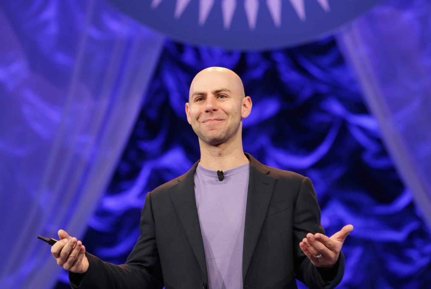 Wharton professor Adam Grant gives a talk on stage at an event.