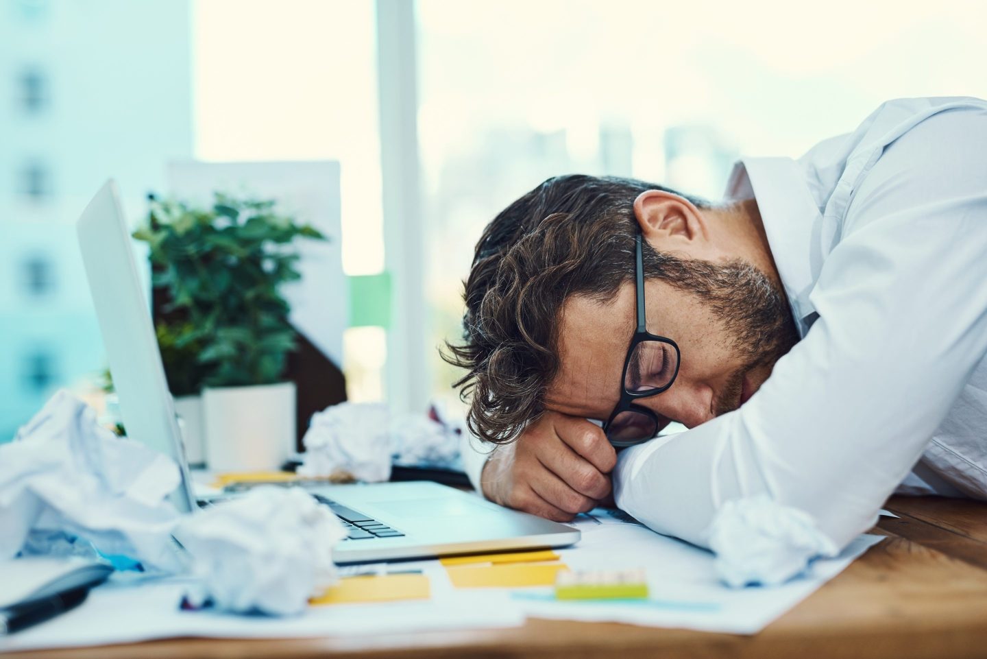 Shot of a young businessman with his head down on an office desk