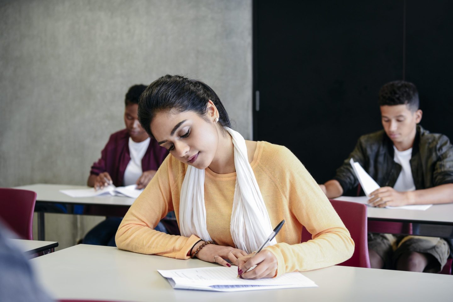 Woman takes an exam in a classroom.